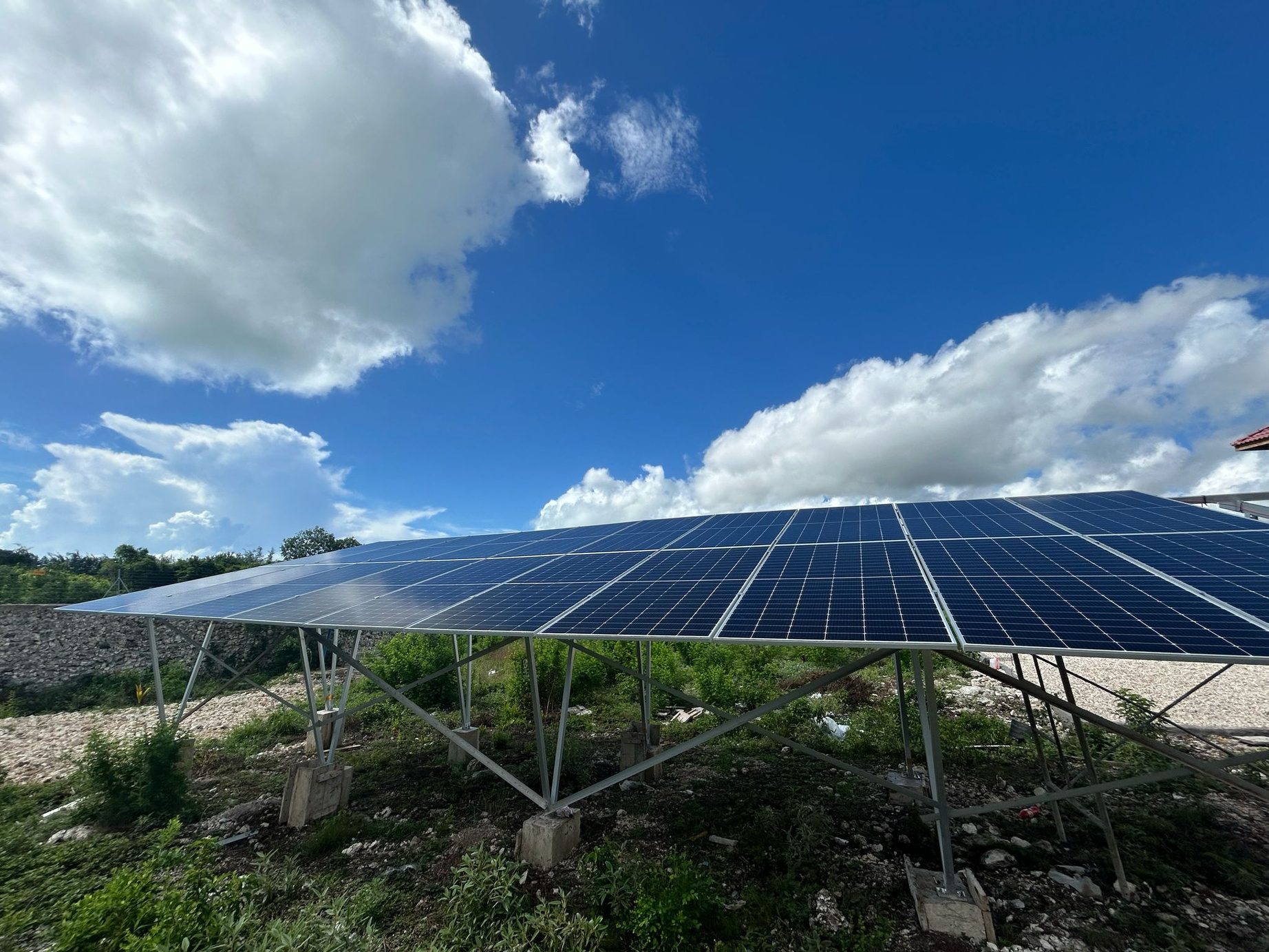 Ground-mounted solar panel array under a bright blue sky